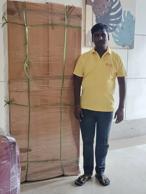 Our packer next to tall furniture packed in corrugated sheet and strapping